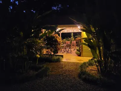 a garden at night with a table and chairs at Cabina Rancho la Merced in Uvita