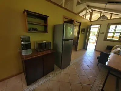 a kitchen with a refrigerator and a microwave at Cabina Rancho la Merced in Uvita