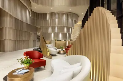 a lobby of a hotel with a staircase and chairs at Hilton San Jose La Sabana in San José