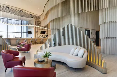 a lobby with a white couch and stairs at Hilton San Jose La Sabana in San José