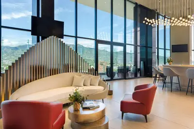 a living room with a couch and chairs and a table at Hilton San Jose La Sabana in San José