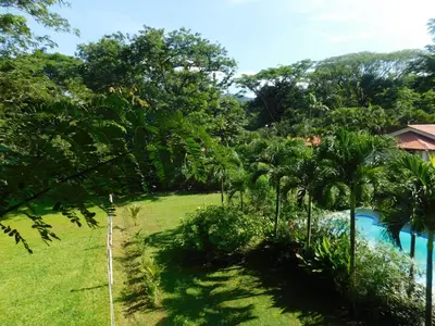 a view of a yard with a pool and trees at Villas jungle 5 in Sámara