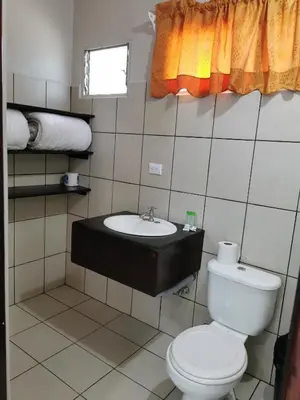 a bathroom with a toilet and a sink at Hotel Puerto San Luis in Tilarán