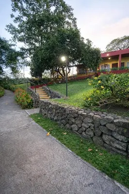 a stone wall next to a building with a street light at Hotel Puerto San Luis in Tilarán