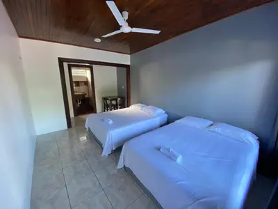 a bedroom with two beds and a ceiling fan at Hotel Puerto San Luis in Tilarán
