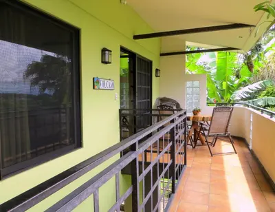 a balcony of a house with a table and chairs at Pura Vida Hotel in Alajuela City
