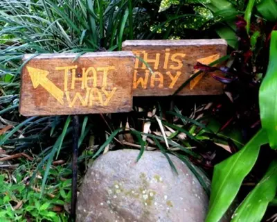 a sign that says kids that way on top of a rock at Pura Vida Hotel in Alajuela City