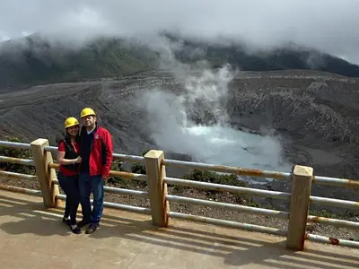 a man and a woman standing on a bridge near a geyser at Pura Vida Hotel in Alajuela City