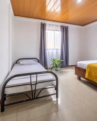 a bedroom with two beds and a window at Casa kattleya in Tortuguero