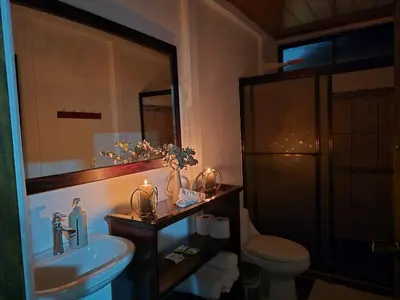 a bathroom with a sink and a toilet and a mirror at Casa kattleya in Tortuguero