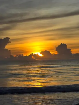 a sunset on the beach with the ocean at Casa kattleya in Tortuguero