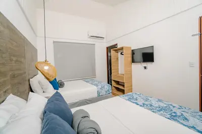 a person laying on a bed in a hotel room at Ocotal Beach House in Sardinal