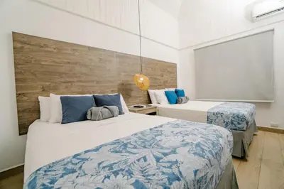 a bedroom with two beds with blue and white sheets at Ocotal Beach House in Sardinal