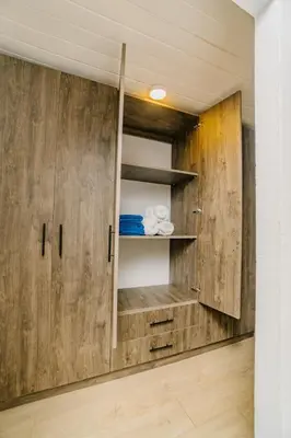 a wooden cabinet in a room with wooden walls at Ocotal Beach House in Sardinal
