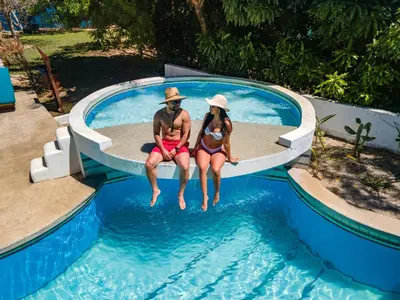 a man and a woman sitting in a swimming pool at Dunama Ocean View Hotel in Playa Flamingo