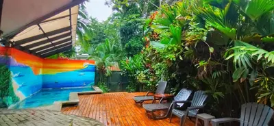a patio with chairs and a swimming pool at Jungle Beach Hotel Manuel Antonio in Manuel Antonio