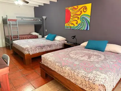a bedroom with two beds and a bunk bed at Jungle Beach Hotel Manuel Antonio in Manuel Antonio
