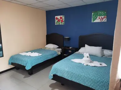 a room with two beds with towels on them at Hotel Palmera Real Hot Springs in Fortuna
