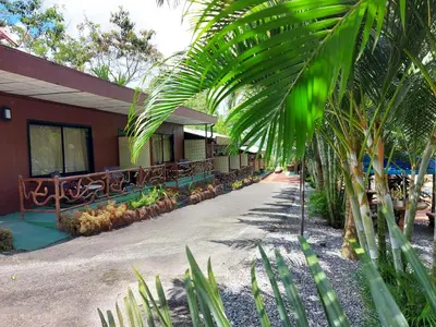 a building with a palm tree in front of it at Hotel Palmera Real Hot Springs in Fortuna