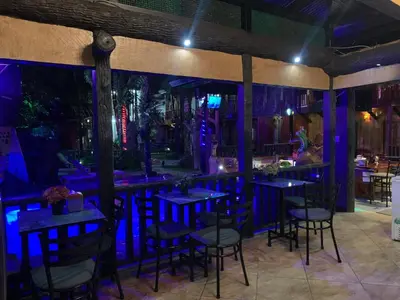 a bar with blue lighting in a restaurant at Poshtel Arenal in Fortuna