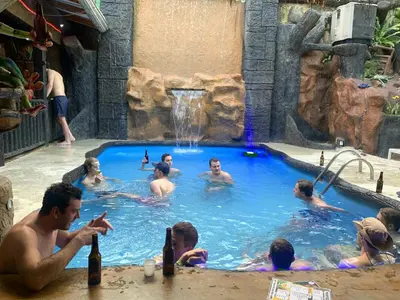 a group of people in a pool at a water park at Poshtel Arenal in Fortuna