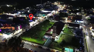 an aerial view of a city at night with a red marker at Poshtel Arenal in Fortuna