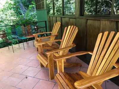 two wooden rocking chairs sitting on a porch at FLOR DE PARAISO BUNGALOWS in Montezuma