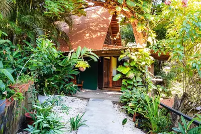 a garden path leading to a house with plants at FLOR DE PARAISO BUNGALOWS in Montezuma