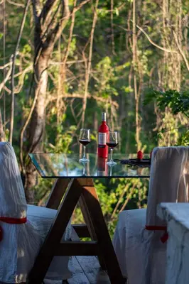 a table with two glasses of wine and two chairs at Marbella Retreats Casa Roja in Santa Cruz