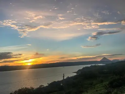 a sunset over the water with a mountain in the distance at Monte Terras in Tronadora