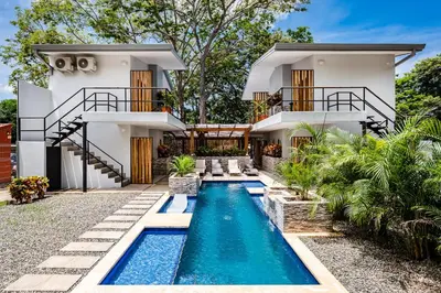 a house with a swimming pool in front of a house at Hotel Elixir in Tamarindo