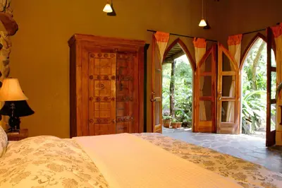 a bedroom with a bed and an open door at Hacienda La Isla Lodge in Sarapiquí