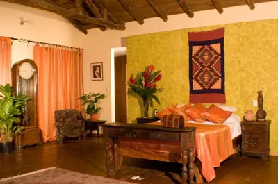 a bedroom with a bed and a table and a desk at Hacienda La Isla Lodge in Sarapiquí
