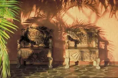 a pair of benches sitting next to a wall at Hacienda La Isla Lodge in Sarapiquí