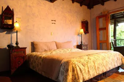a bedroom with a bed and two lamps and a window at Hacienda La Isla Lodge in Sarapiquí