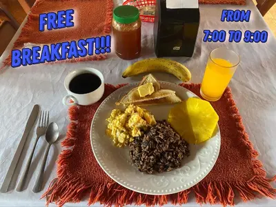 a plate of breakfast with eggs and toast and coffee at Hotel La Choza Inn in Fortuna