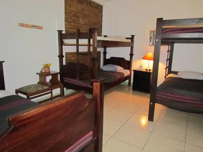 a room with three bunk beds in a room at Hostel Shakti in San José