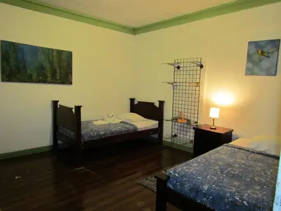 a room with two beds and a bird cage at Hostel Shakti in San José