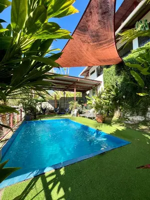 a swimming pool in the yard of a house at Villas Jacquelina in Quepos