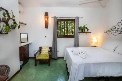 a bedroom with a bed and a window and a chair at Villas Jacquelina in Quepos