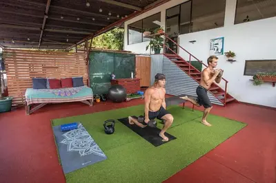 two men are doing yoga in a living room at Villas Jacquelina in Quepos