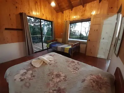 a bedroom with a bed in a room with wooden walls at Cabinas Capulin & Farm in Monteverde Costa Rica