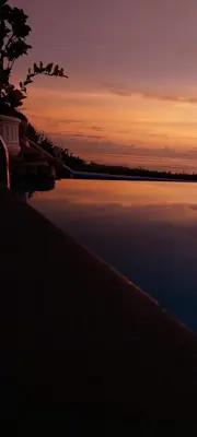 a large body of water with a sunset in the background at Vista Ballena in Uvita