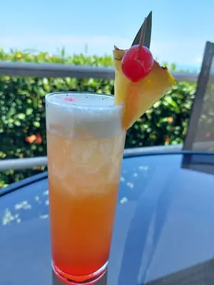 a drink with a piece of pineapple and a cherry at Vista Ballena in Uvita