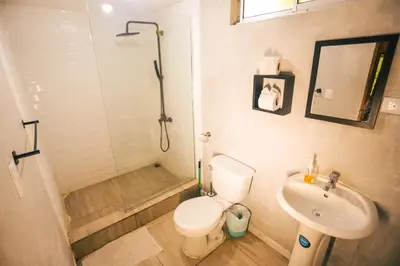 a bathroom with a shower and a toilet and a sink at Cabinas Playa Surf Hostel in Santa Teresa Beach