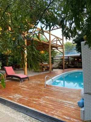a wooden deck with a pool and a pavilion at Cabinas Playa Surf Hostel in Santa Teresa Beach