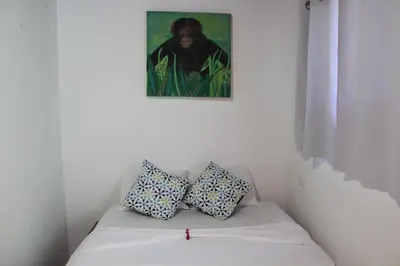 a couch with two pillows sitting under a painting at Cabinas Playa Surf Hostel in Santa Teresa Beach