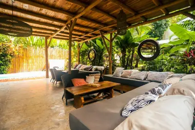 a living room with couches and a table at Cabinas Playa Surf Hostel in Santa Teresa Beach