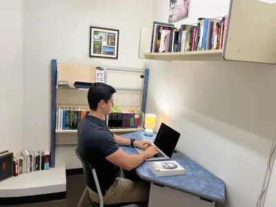 a man sitting at a desk with a laptop at Legacy Boutique Hotel in Quesada