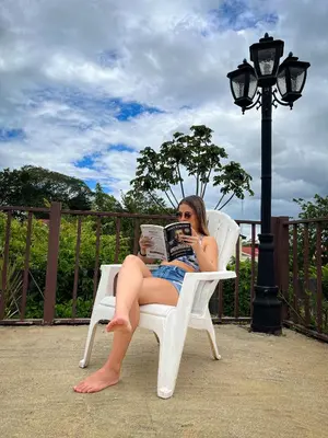 a woman sitting in a chair reading a book at Legacy Boutique Hotel in Quesada